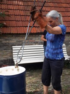 Raku Keramist haalt werkstuk met een tang uit de raku oven